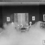 Experimental lab test of new central air conditioning unit which diffuses cool air at floor level; smoke making cool air visible has risen to the 3-ft-high level. July 1945.